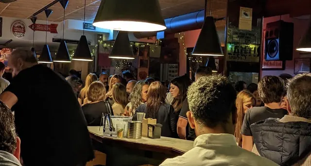 Clientes en la barra de El Plaza bajo las lámparas negras