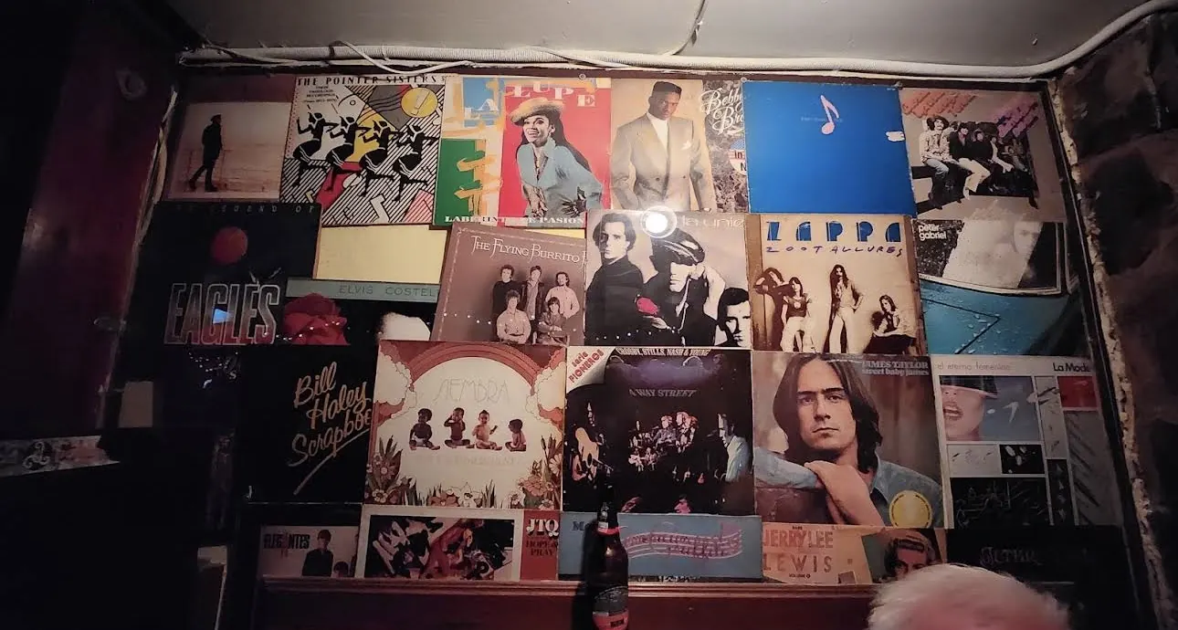 Detalle de la pared de discos con portadas de Eagles, Zappa y James Taylor